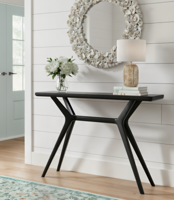 Black entryway table in bright room with white walls.